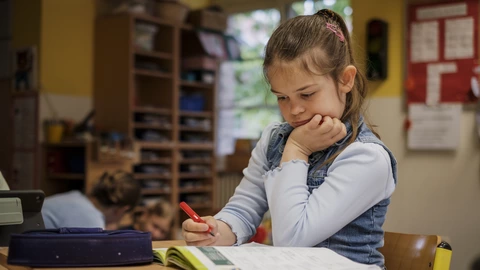 Ein junges Kind, das konzentriert an einer Aufgabe arbeitet.