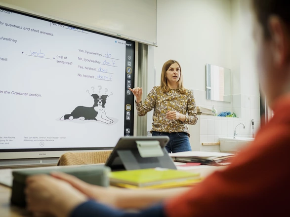 Eine Lehrerin in einer CJD Christophorusschule steht an einer digitalen Tafel und unterrichtet.