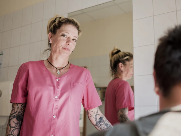 Eine Krankenschwester in einer CJD Fachklinik lächelt in die Kamera.